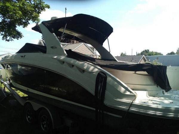 Slide: The Image of 2010 Chaparral 276ssx boat with black canopy on trailer, parked outdoors. - 1