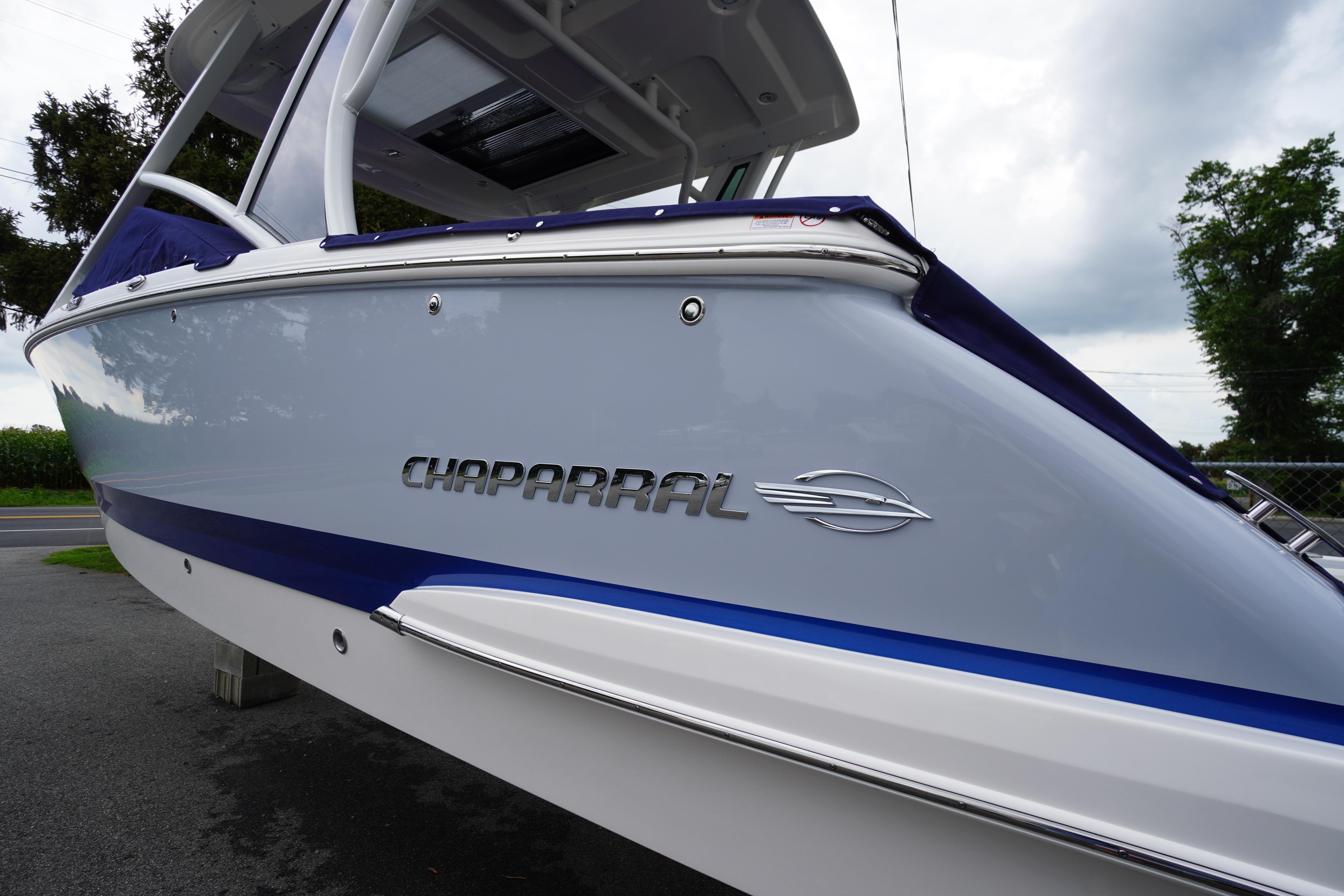 Slide: The Image of 2025 Chaparral 280 OSX boat, sleek design with logo, parked outdoors. - 1