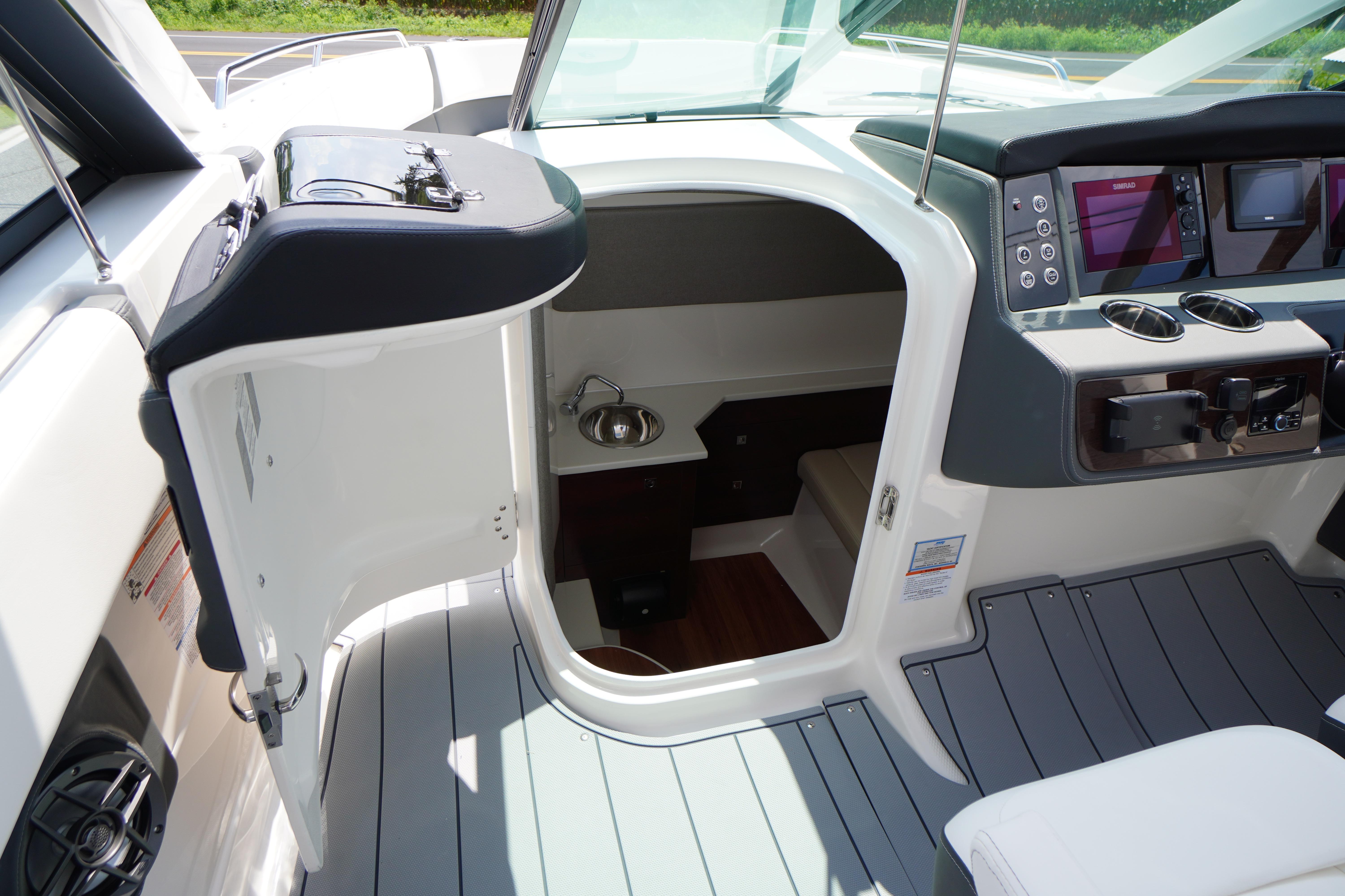 Slide: The Image of 2025 Chaparral 280 OSX boat interior with helm, open cabin door, and modern controls. - 26
