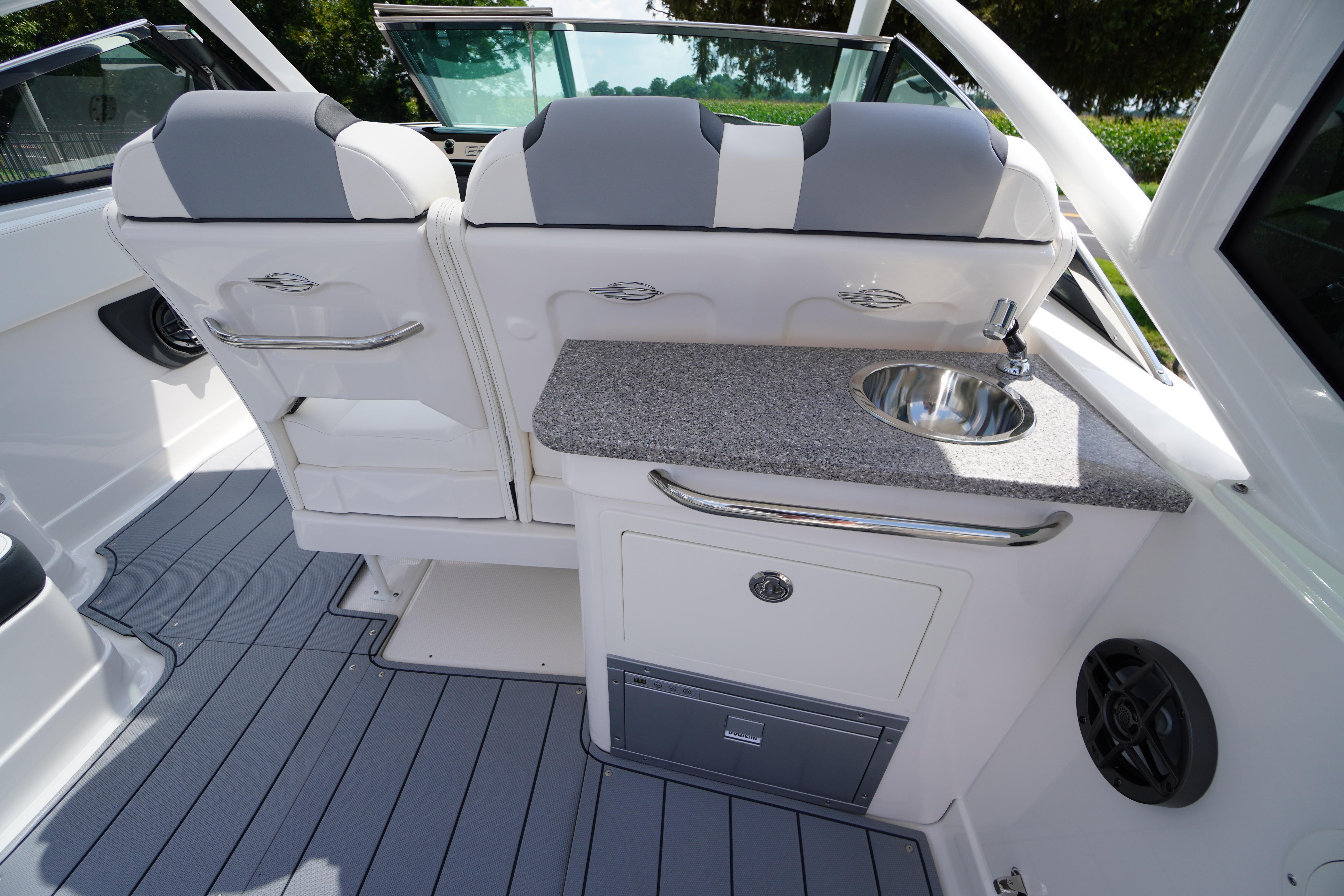 Slide: The Image of 2025 Chaparral 280 OSX boat interior with seating, sink, and storage. - 33