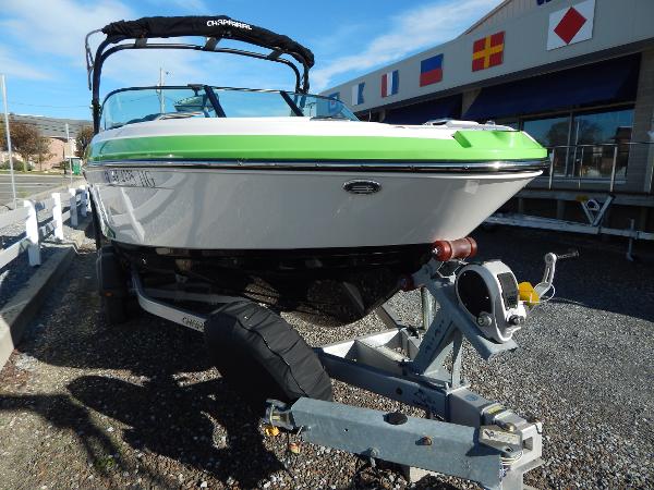 Slide: The Image of 2015 Chaparral Vortex 223 VRX boat on a trailer, green and white exterior. - 2