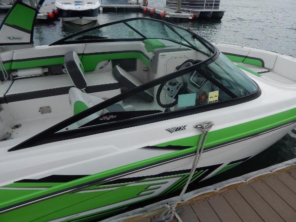 Slide: The Image of 2015 Chaparral Vortex 223 VRX boat docked, green and white exterior. - 46