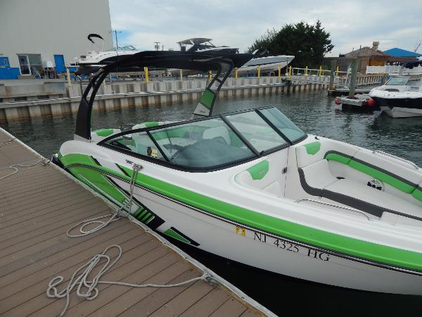 Slide: The Image of 2015 Chaparral Vortex 223 VRX boat docked at marina with green accents. - 48