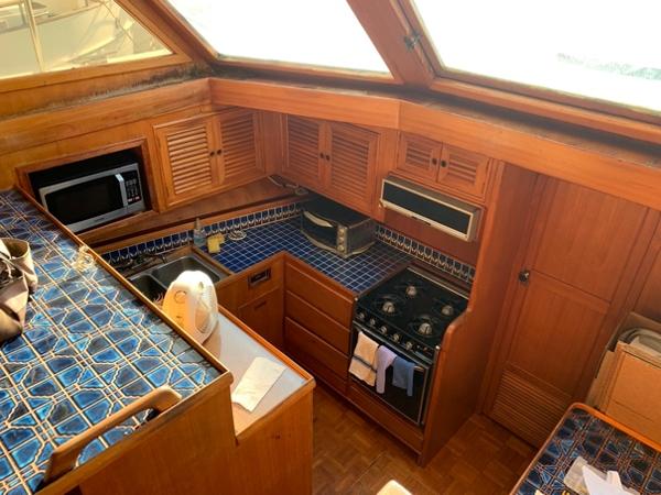 Slide: The Image of 1984 CHB 48 yacht kitchen with blue tile countertops and wooden cabinetry. - 17