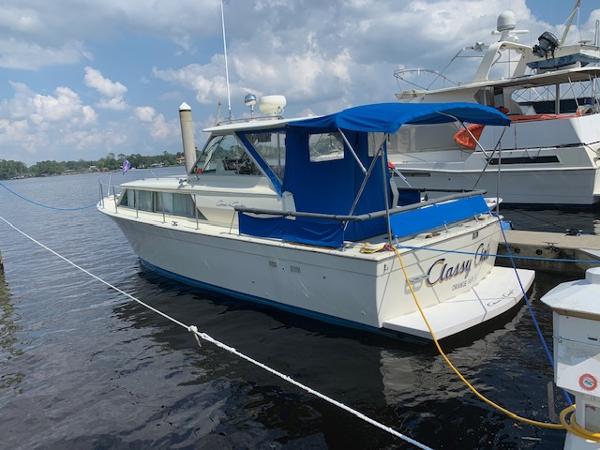 Slide: The Image of 1968 Chris-Craft 31 Commander boat docked with blue canopy and calm waters. - 0