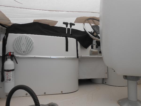 Slide: The Image of 1989 Chris-Craft Amerosport 320 cockpit with steering wheel, controls, and fire extinguisher. - 12