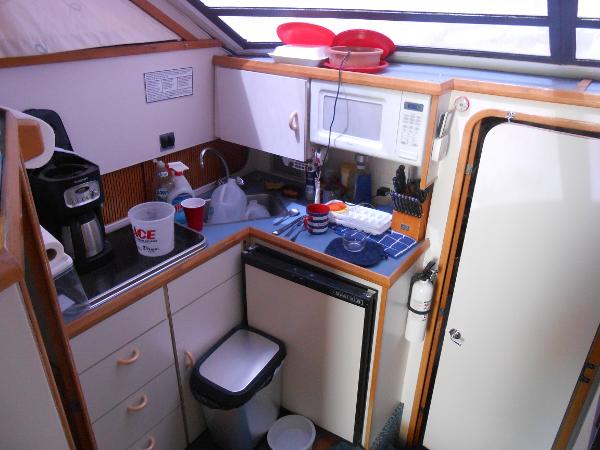 Slide: The Image of 1989 Chris-Craft Amerosport 320 yacht kitchen with microwave, sink, and storage cabinets. - 13