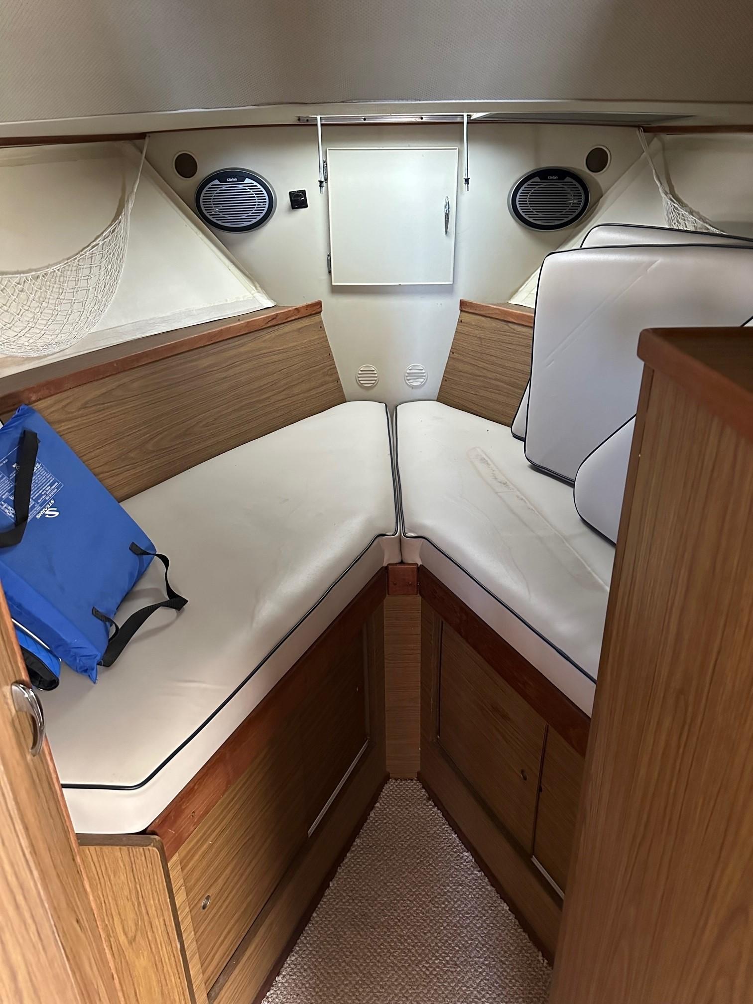 Slide: The Image of Interior cabin of a 1968 Chris-Craft 35 Commander boat with white cushions and wooden accents. - 20