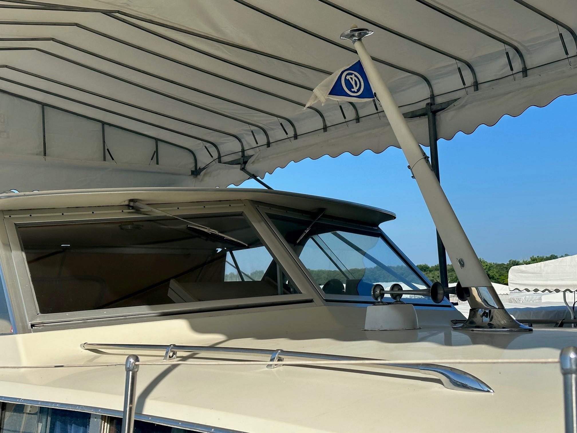 Slide: The Image of 1968 Chris-Craft 35 Commander boat under canopy, close-up of cabin and flagpole. - 29