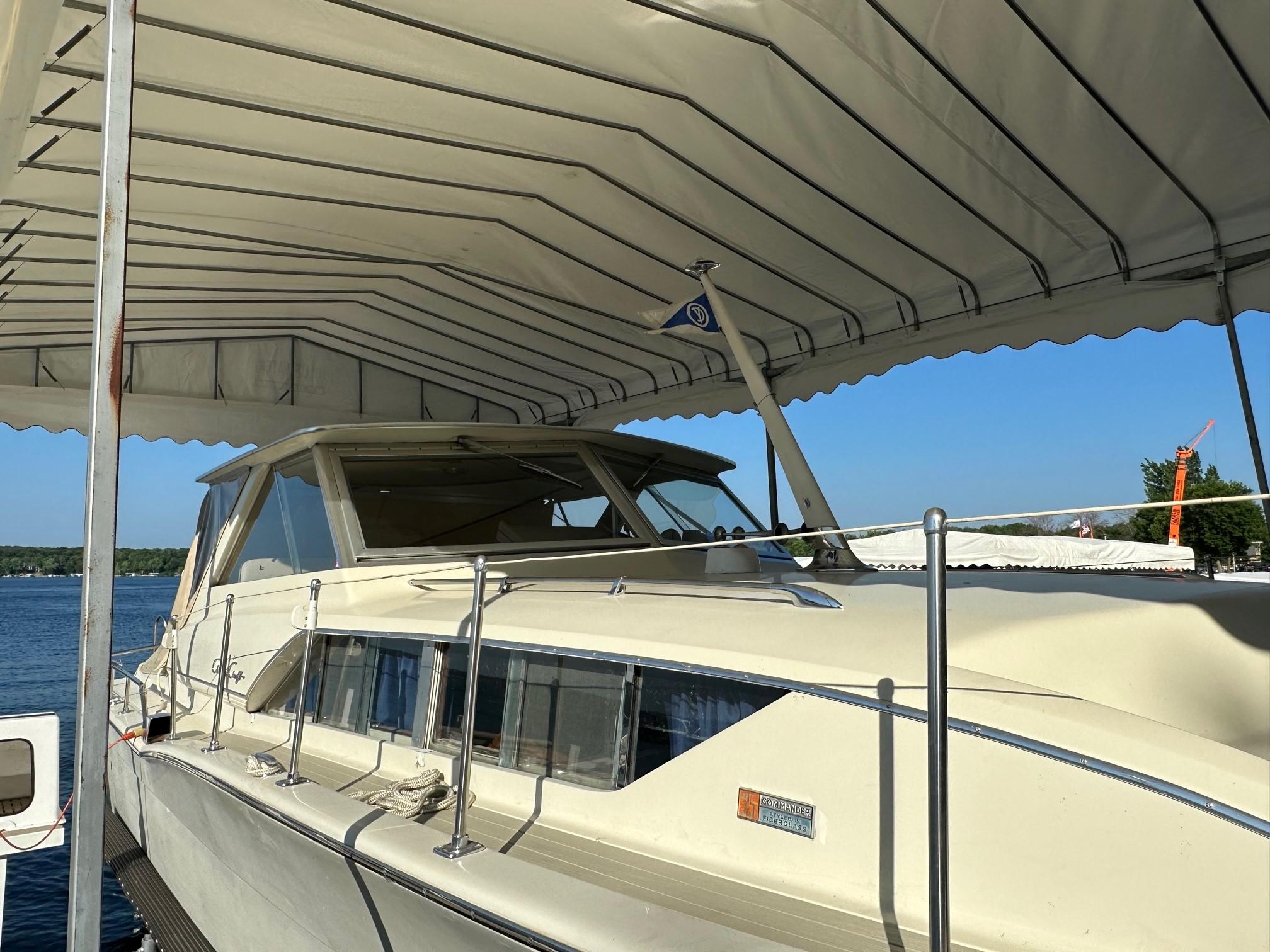 Slide: The Image of 1968 Chris-Craft 35 Commander docked under a canopy on a sunny day. - 30