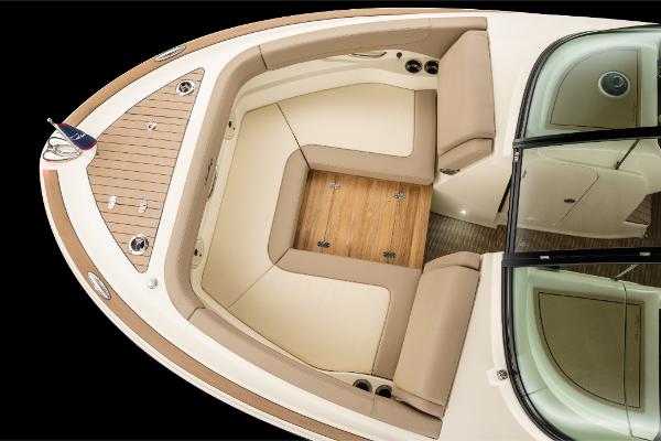 Slide: The Image of 2023 Chris-Craft Calypso 27 boat interior with beige seating and wooden flooring. - 18