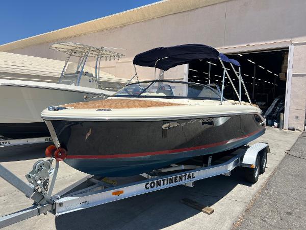 Slide: The Image of 2020 Chris-Craft Capri 21 boat on a Continental trailer outside a warehouse. - 3