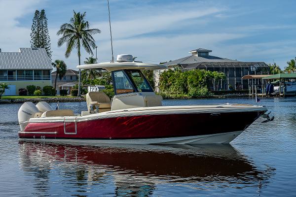 Slide: The Image of 2019 Chris-Craft Catalina 27 boat on calm water, surrounded by tropical scenery. - 0
