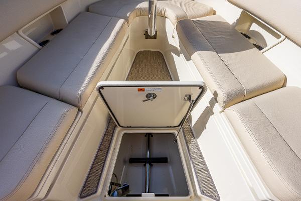 Slide: The Image of 2019 Chris-Craft Catalina 27 interior with open storage compartment and cushioned seating. - 13