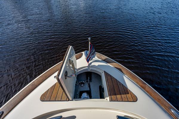 Slide: The Image of 2019 Chris-Craft Catalina 27 boat bow with open hatch on calm water. - 14