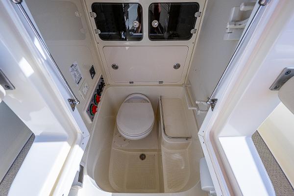 Slide: The Image of 2019 Chris-Craft Catalina 27 boat bathroom interior with toilet and storage compartments. - 18