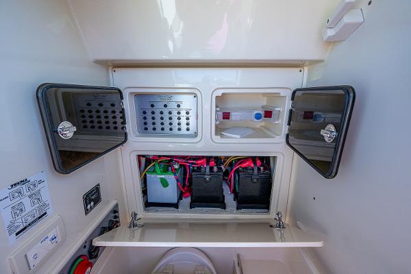 Slide: The Image of 2019 Chris-Craft Catalina 27 electrical panel with open compartments and visible wiring. - 19