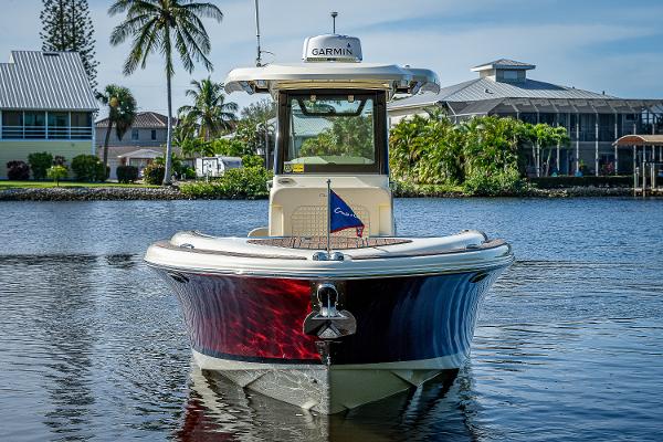 Slide: The Image of 2019 Chris-Craft Catalina 27 boat on calm water, with tropical background. - 2