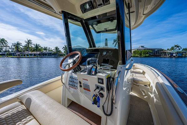 Slide: The Image of 2019 Chris-Craft Catalina 27 boat interior with steering wheel, dashboard, and waterfront view. - 21