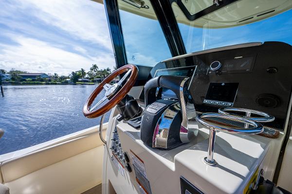 Slide: The Image of 2019 Chris-Craft Catalina 27 helm with wooden steering wheel and modern controls. - 22