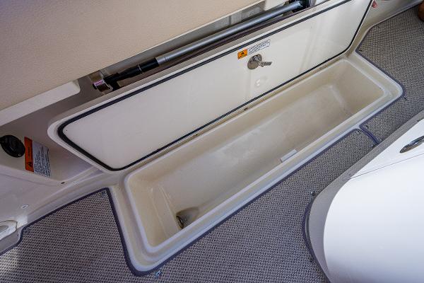 Slide: The Image of 2019 Chris-Craft Catalina 27 storage compartment with open lid, showcasing spacious interior. - 27