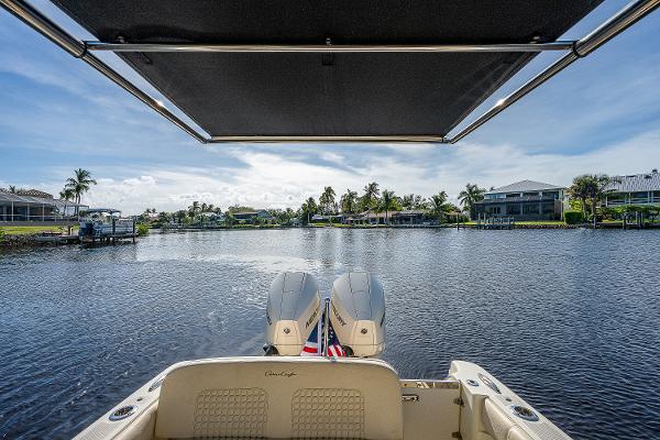 Slide: The Image of 2019 Chris-Craft Catalina 27 boat on a serene waterway, featuring dual outboard engines. - 32