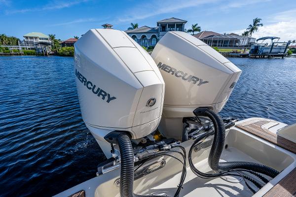 Slide: The Image of 2019 Chris-Craft Catalina 27 with dual Mercury outboard engines on a sunny waterfront. - 35