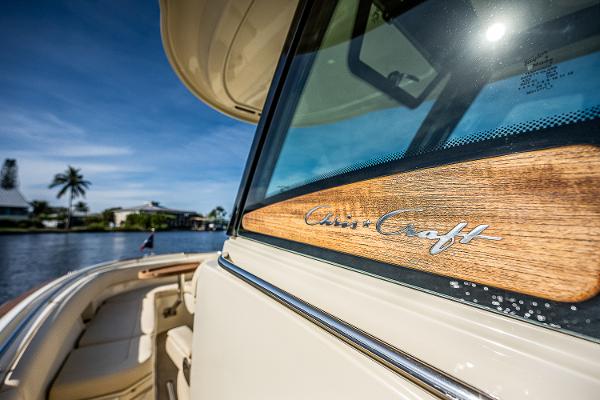 Slide: The Image of 2019 Chris-Craft Catalina 27 boat with wooden trim, docked by a scenic waterfront. - 39