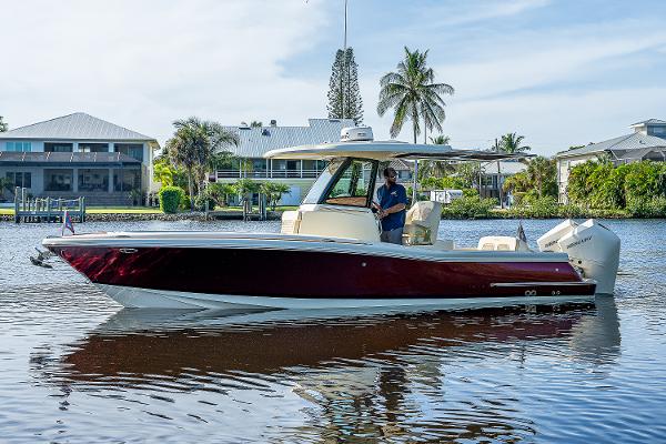Slide: The Image of 2019 Chris-Craft Catalina 27 boat on calm water, with scenic waterfront background. - 4