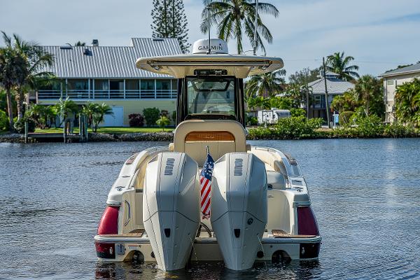 Slide: The Image of 2019 Chris-Craft Catalina 27 boat on water, rear view with twin engines and American flag. - 6