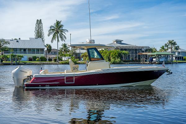 Slide: The Image of 2019 Chris-Craft Catalina 27 boat on calm water, surrounded by tropical scenery. - 7