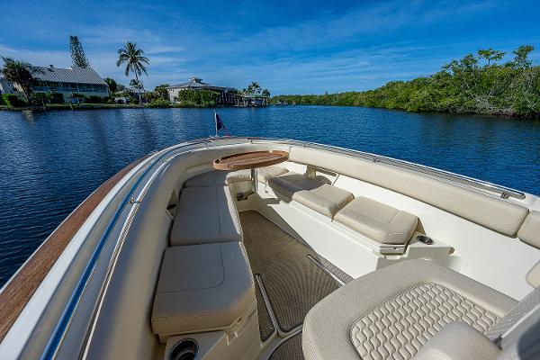 Slide: The Image of 2019 Chris-Craft Catalina 27 boat with luxurious seating on a serene waterway. - 9