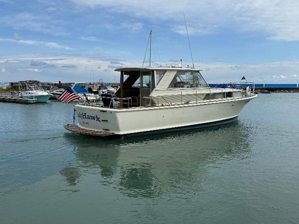 Slide: The Image of 1969 Chris-Craft Commander boat docked in a marina, featuring classic design and American flag. - 11