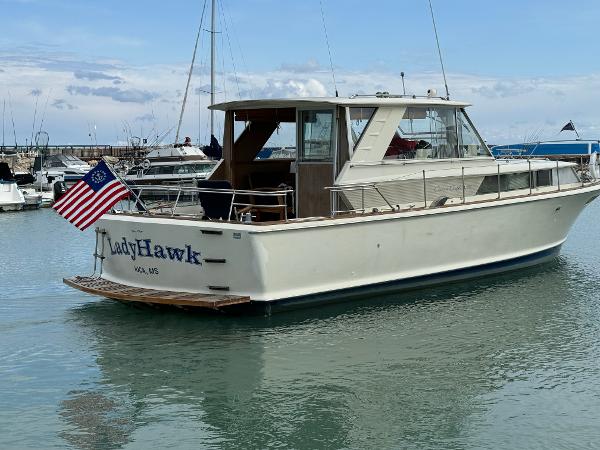 Slide: The Image of 1969 Chris-Craft Commander boat named LadyHawk docked in a marina. - 12