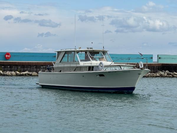 Slide: The Image of 1969 Chris-Craft Commander boat on water near a dock under cloudy sky. - 15