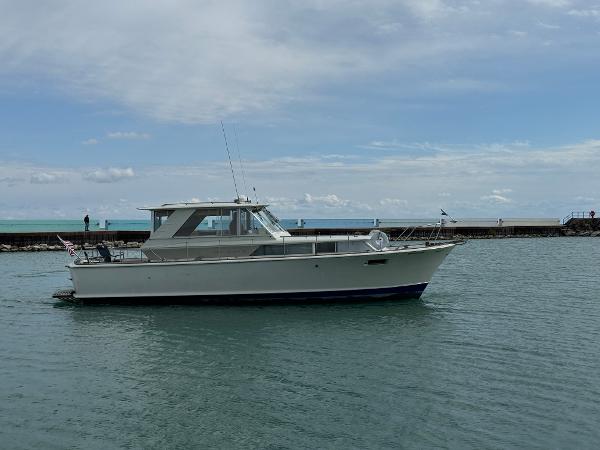 Slide: The Image of 1969 Chris-Craft Commander boat on calm water with cloudy sky background. - 16