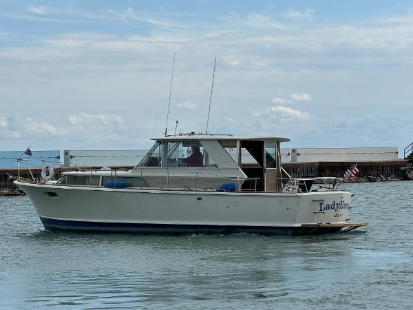 Slide: The Image of 1969 Chris-Craft Commander boat on water, side view, with clear sky background. - 24