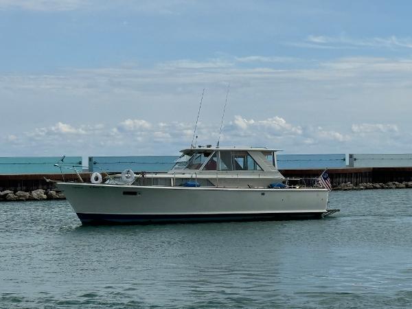 Slide: The Image of 1969 Chris-Craft Commander boat on calm water, clear sky background. - 28