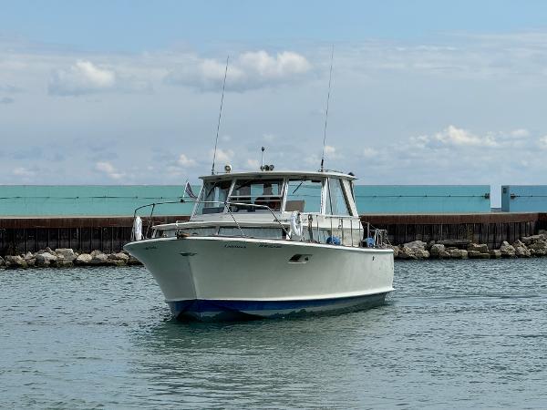 Slide: The Image of 1969 Chris-Craft Commander boat on calm water near a rocky shoreline. - 31
