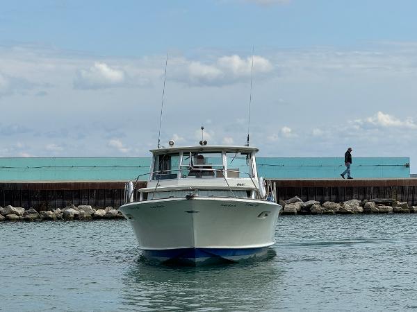 Slide: The Image of 1969 Chris-Craft Commander boat on water near a pier, under a partly cloudy sky. - 32