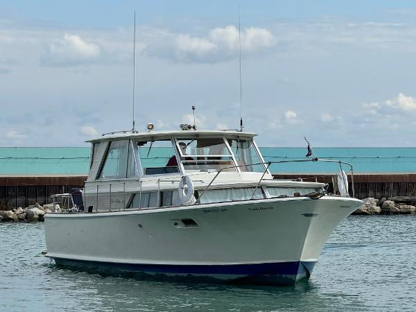 Slide: The Image of 1969 Chris-Craft Commander boat on calm water, clear sky background. - 35