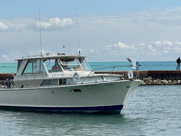 Slide: The Image of 1969 Chris-Craft Commander boat cruising near a pier on a cloudy day. - 36