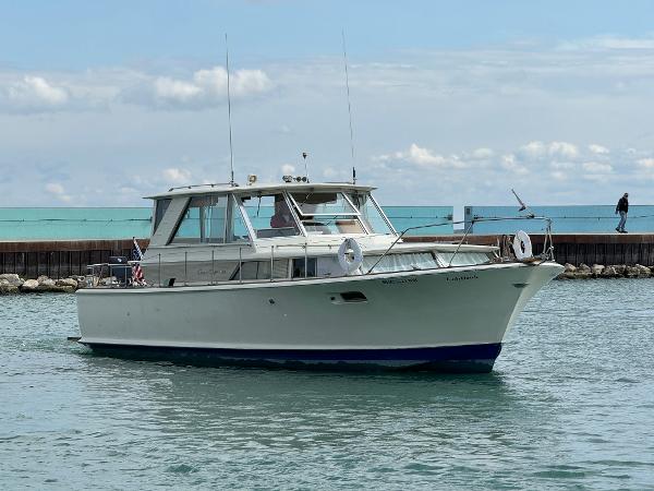 Slide: The Image of 1969 Chris-Craft Commander boat on calm water, clear sky background. - 37