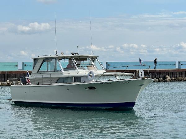Slide: The Image of 1969 Chris-Craft Commander boat on calm water, with a clear sky backdrop. - 38