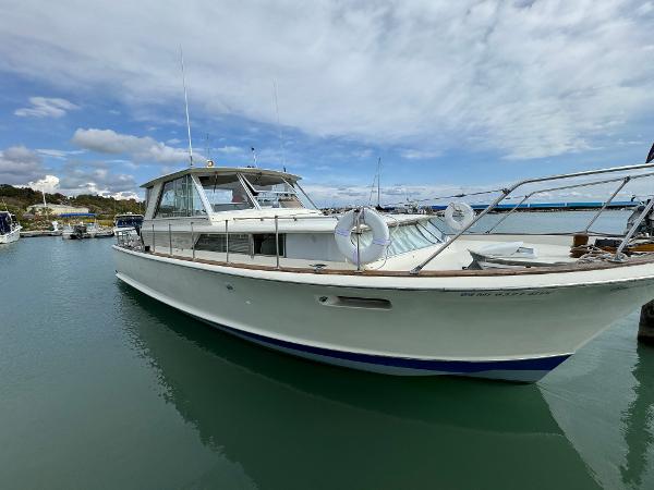 Slide: The Image of 1969 Chris-Craft Commander boat docked in a marina under a partly cloudy sky. - 4