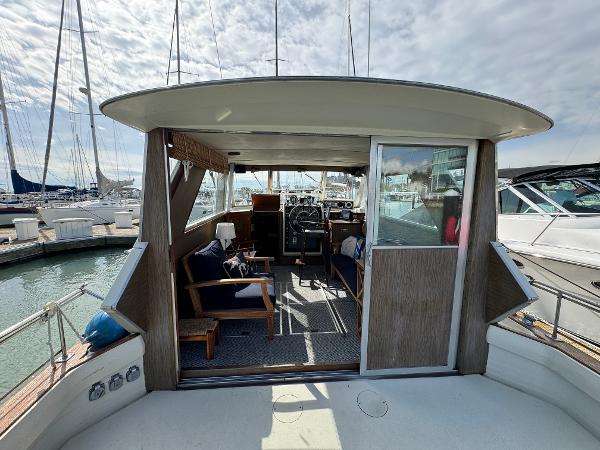 Slide: The Image of 1969 Chris-Craft Commander yacht interior with seating and helm, docked at marina. - 43