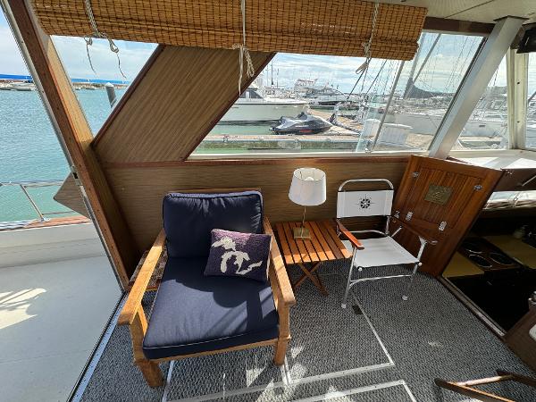 Slide: The Image of 1969 Chris-Craft Commander interior with seating, table, and marina view. - 47