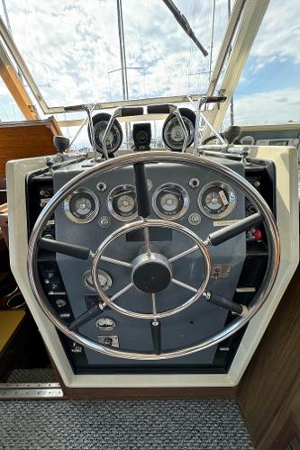 Slide: The Image of 1969 Chris-Craft Commander helm with classic gauges and steering wheel, under a sunny sky. - 49