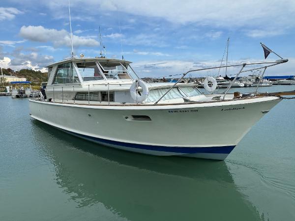 Slide: The Image of 1969 Chris-Craft Commander boat docked in a marina under a partly cloudy sky. - 5