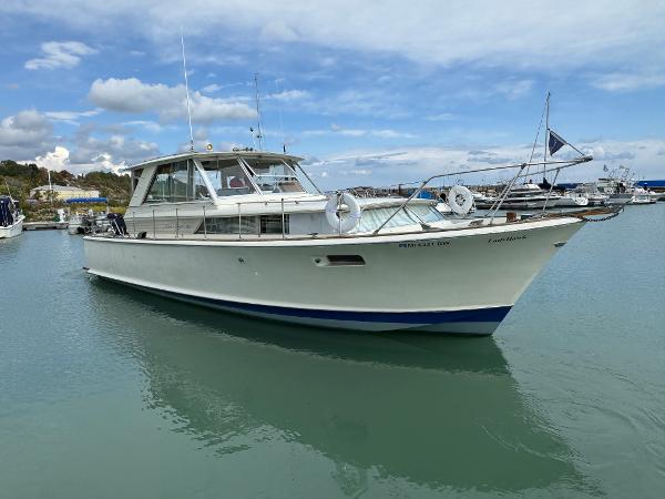 Slide: The Image of 1969 Chris-Craft Commander boat docked in a marina under a partly cloudy sky. - 6